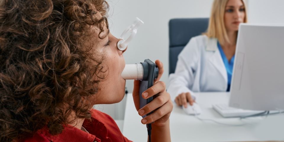 Menino fazendo exame com supervisão da médica