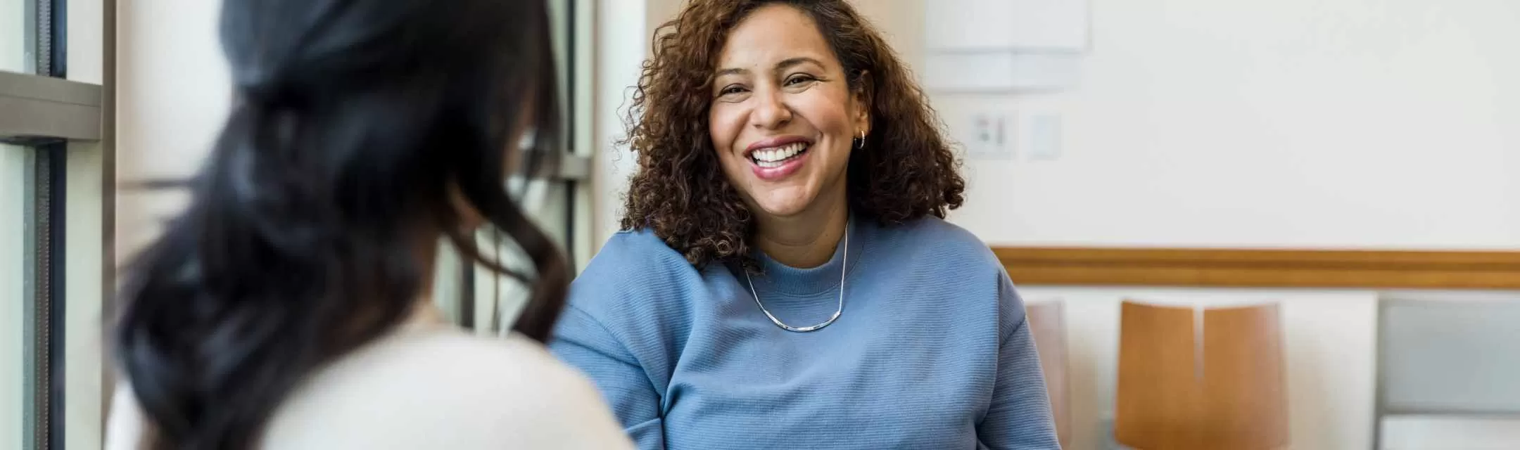 Mulher sorrindo para sua médica