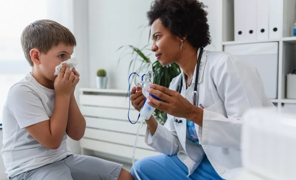 Menino assoando o nariz e médica