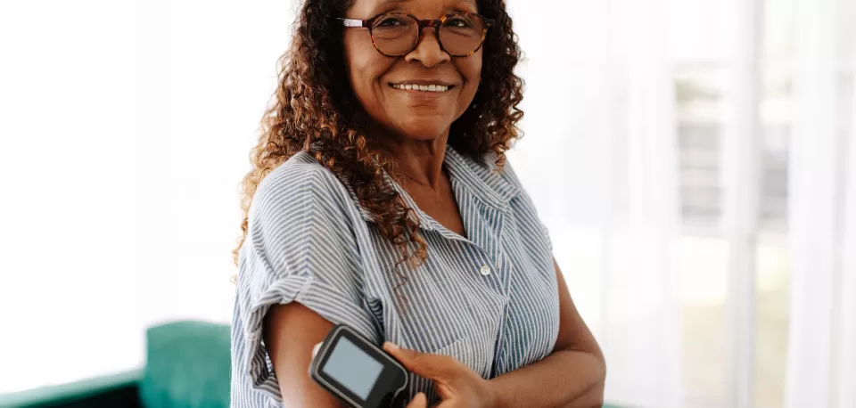 Mulher usando aparelho de monitoramento de glicose para diabetes