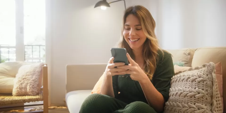 Mulher feliz lendo no celular