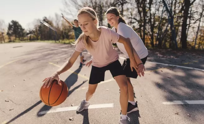 Garotas jogando basquete ao ar livre