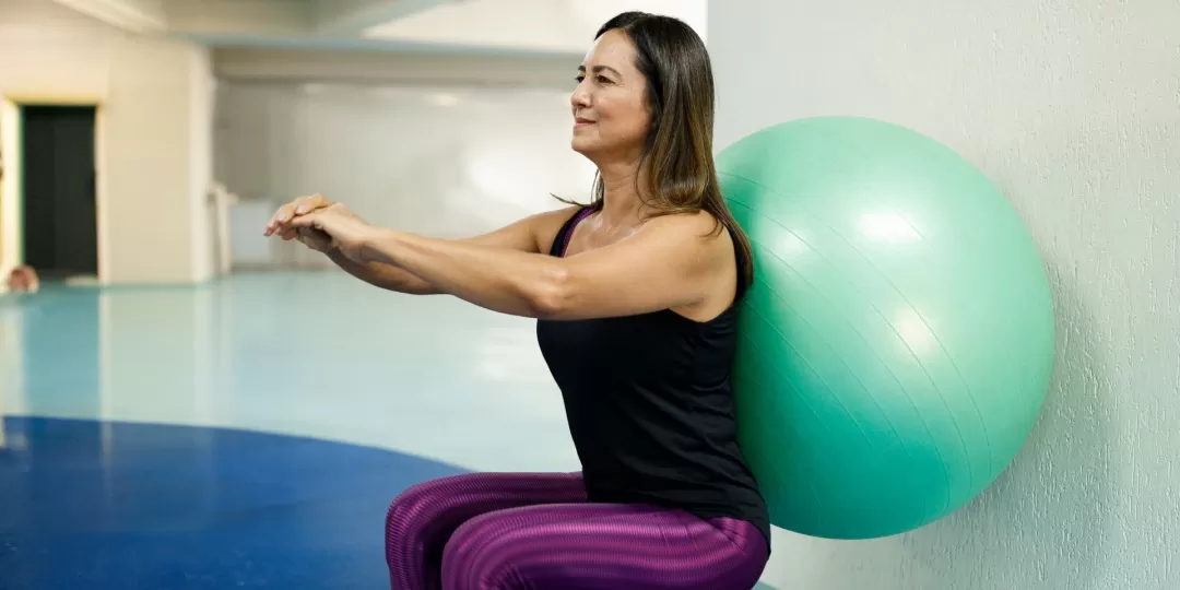 Mulher se exercita em sala fechada